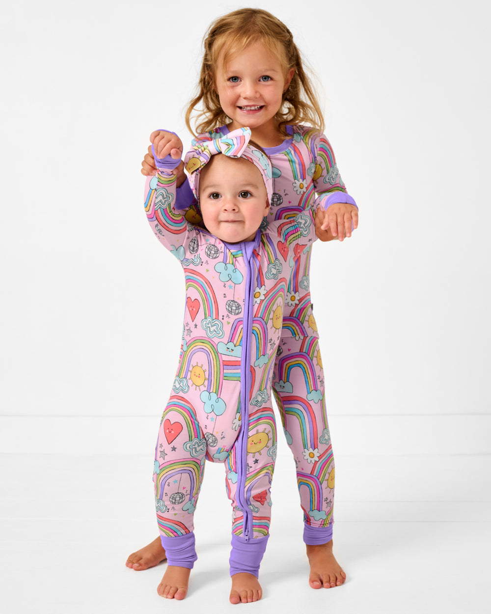 Two girls wearing matching Disco Rainbows bamboo pajamas