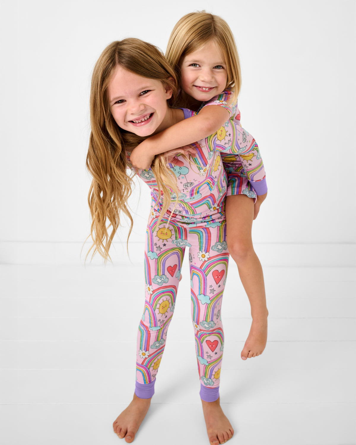 Two girls wearing mathing Disco Rainbows Two-Piece Pajama Sets