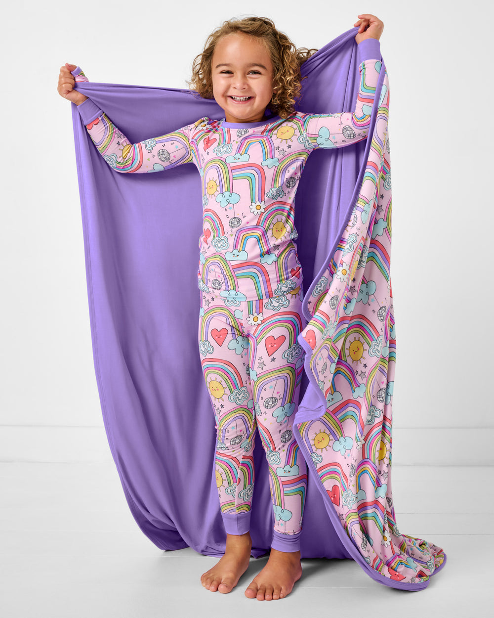 Standing girl holding up the Disco Rainbows Large Cloud Blanket® showing the solid purple side