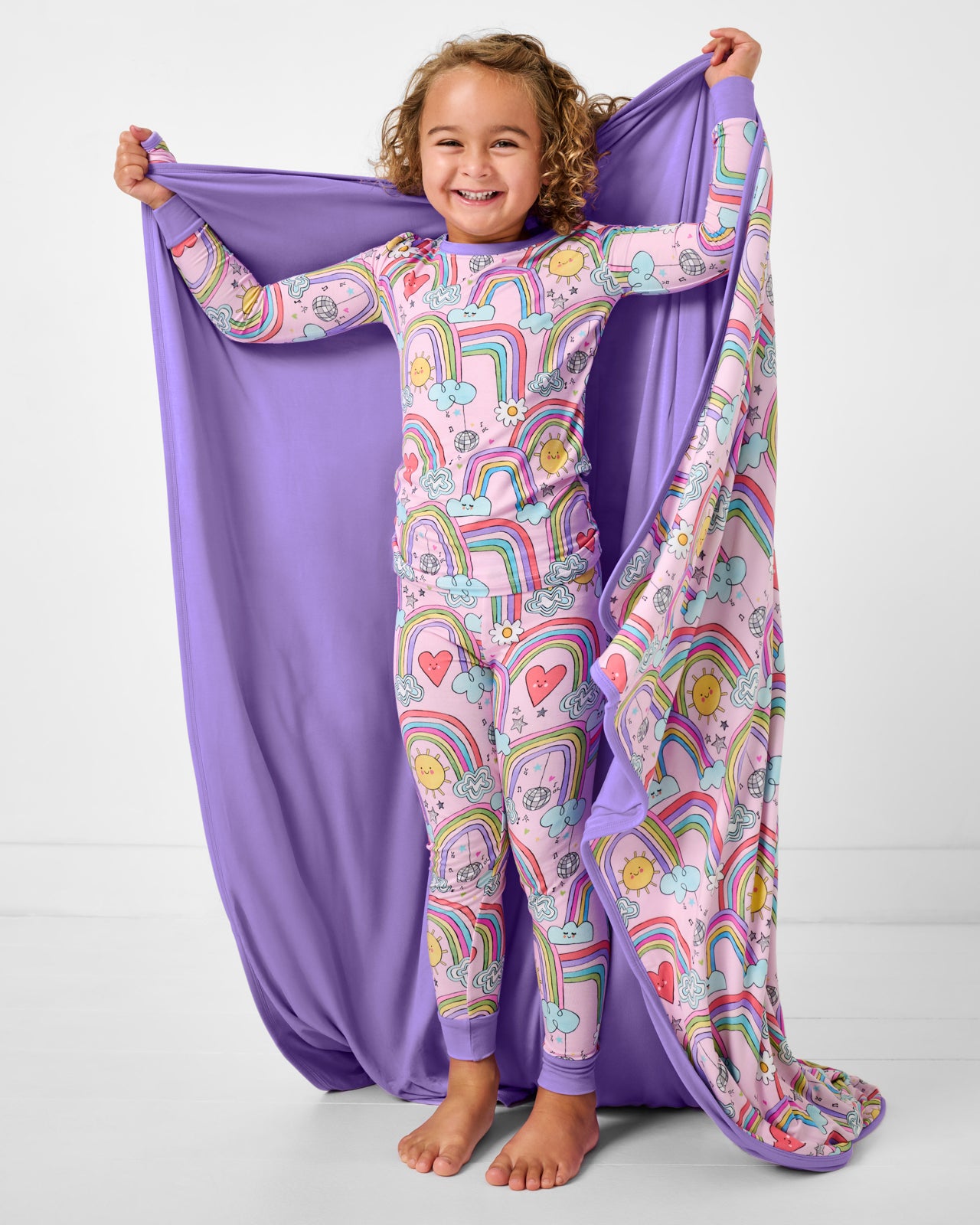 Standing girl holding up the Disco Rainbows Large Cloud Blanket® showing the solid purple side