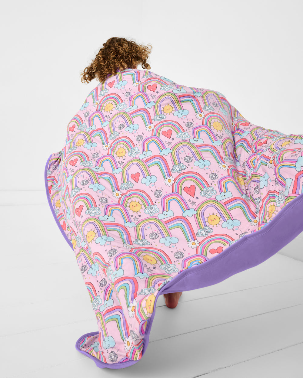 Child in motion holding the Disco Rainbows Large Cloud Blanket®