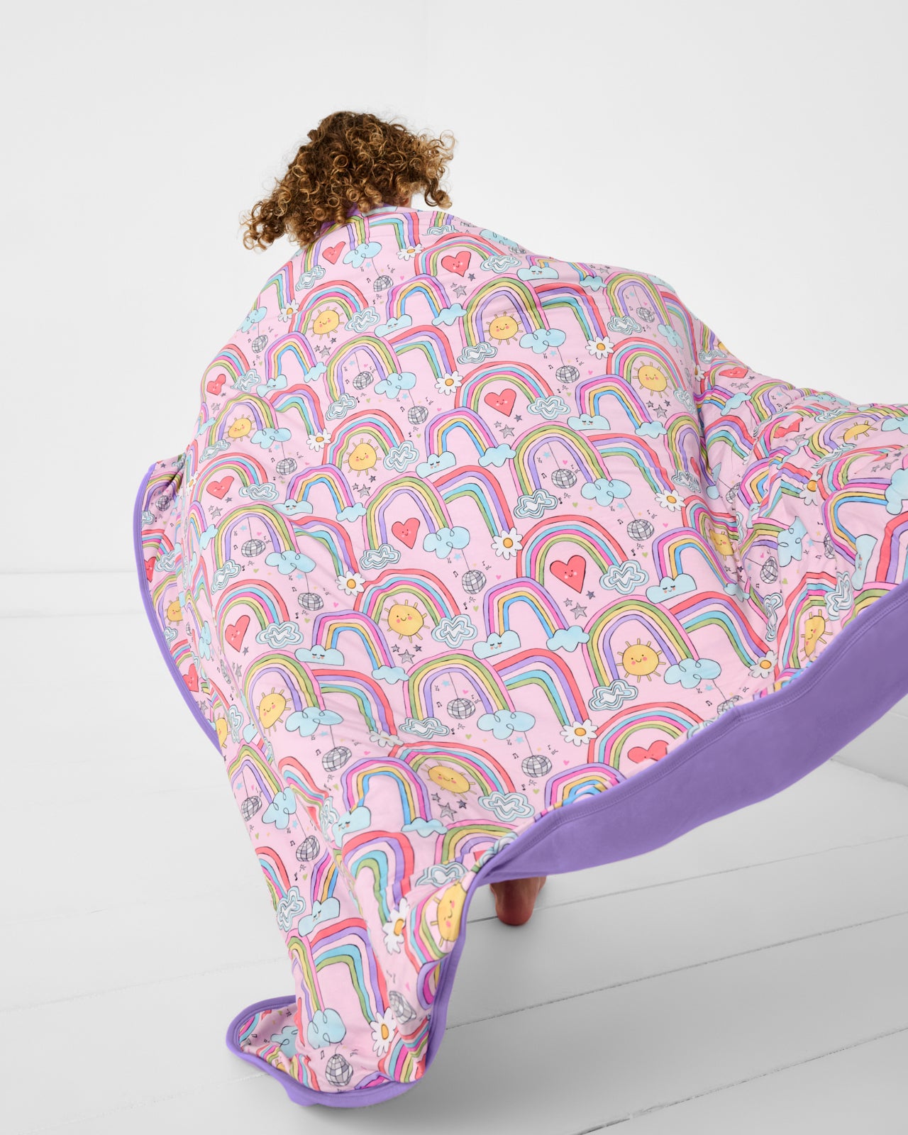 Child in motion holding the Disco Rainbows Large Cloud Blanket®