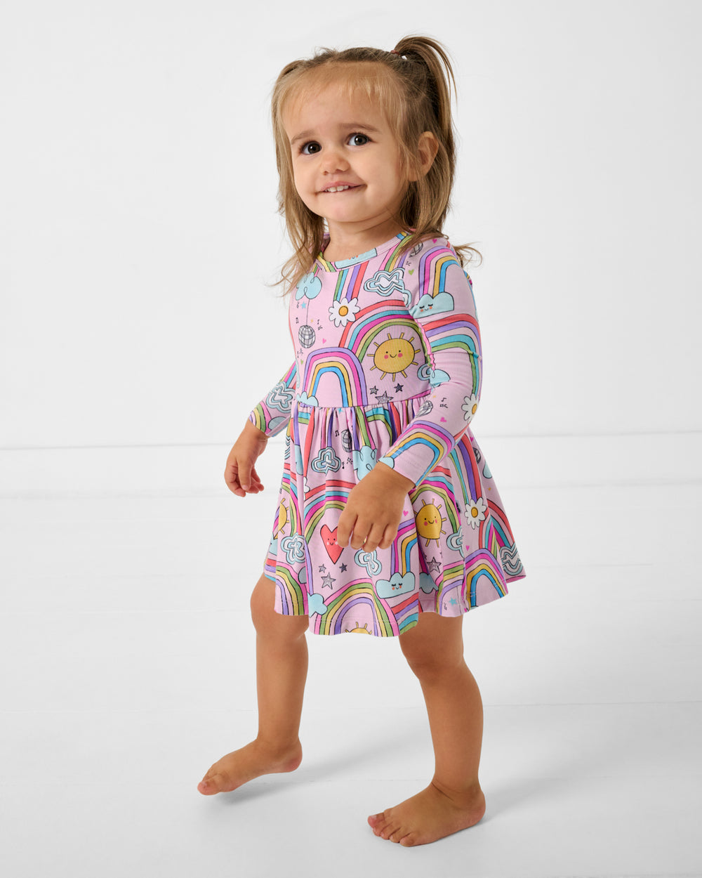 Walking toddler wearing the Disco Rainbows Skater Dress with Bodysuit