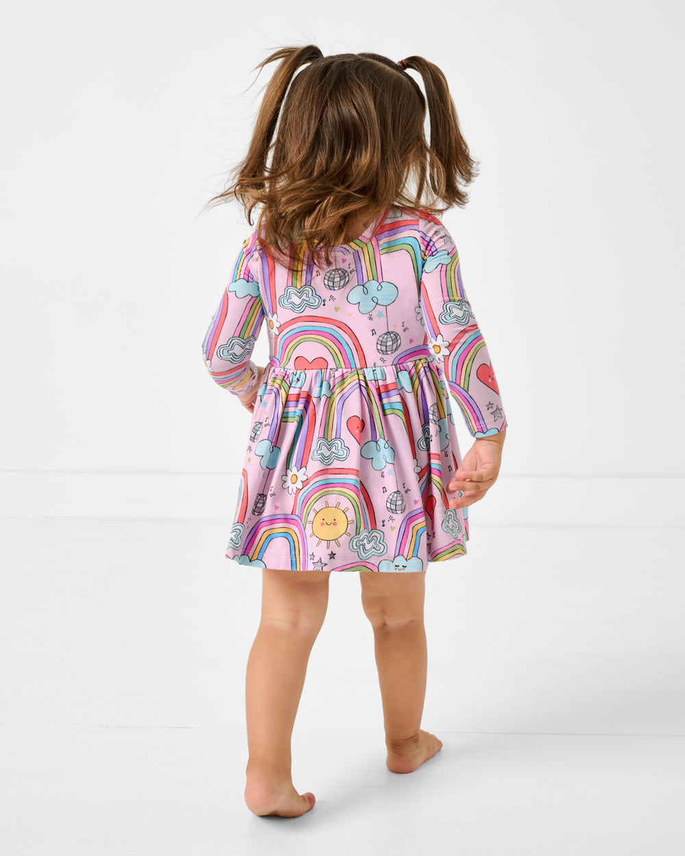 Back view of child wearing the Disco Rainbows Skater Dress with Bodysuit