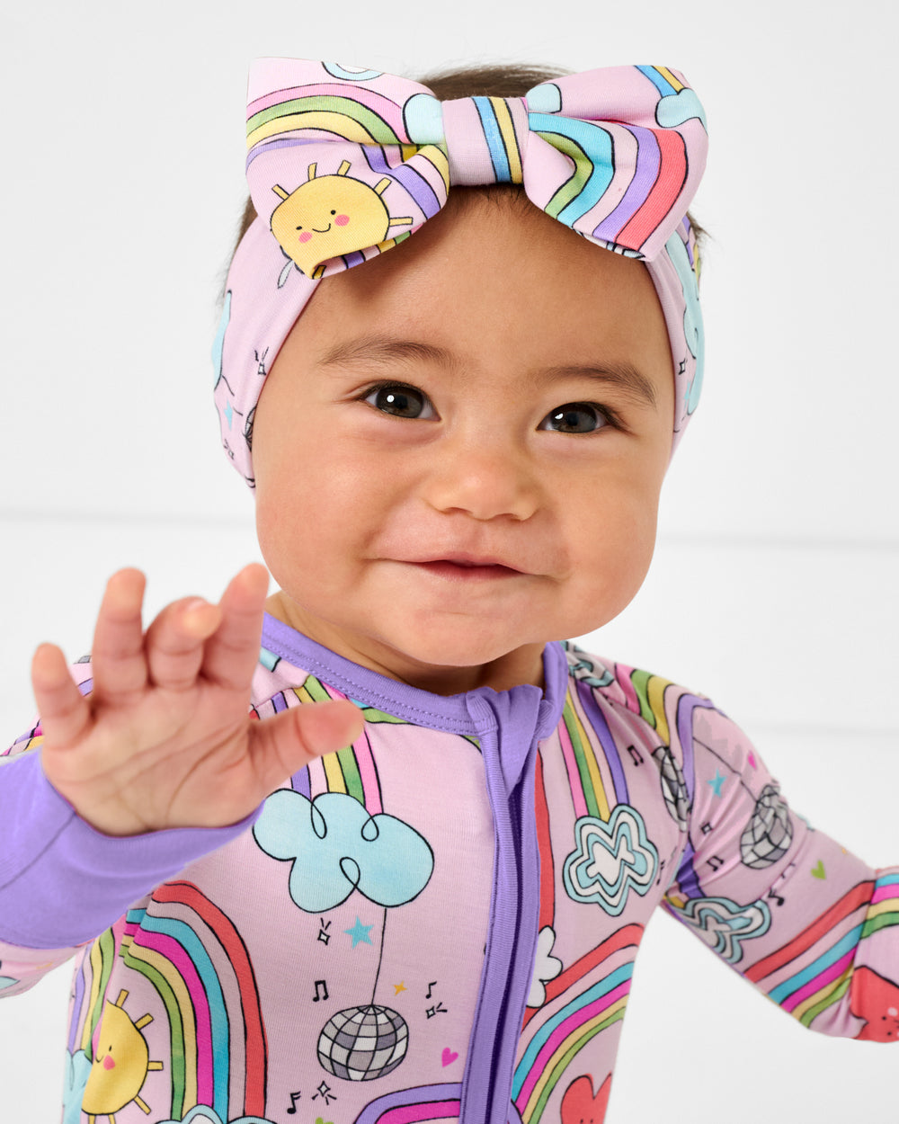 Baby wearing the Disco Rainbows Luxe Bow Headband