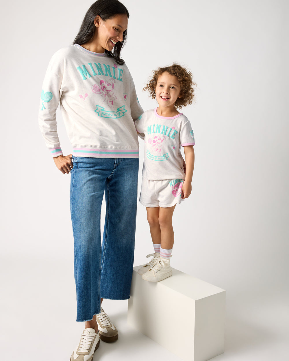 Mother and daughter wearing matching Disney Minnie Mouse Queen of Swing tops