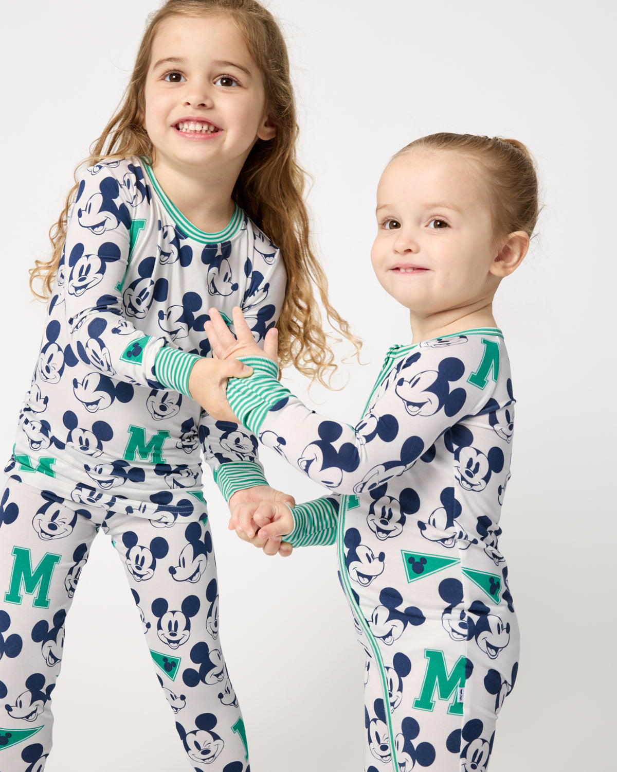 Two girls wearing matching Disney Varsity Mickey Mouse pajamas