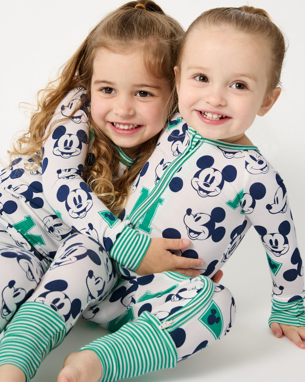 Two girls wearing matching Disney Varsity Mickey Mouse pajamas