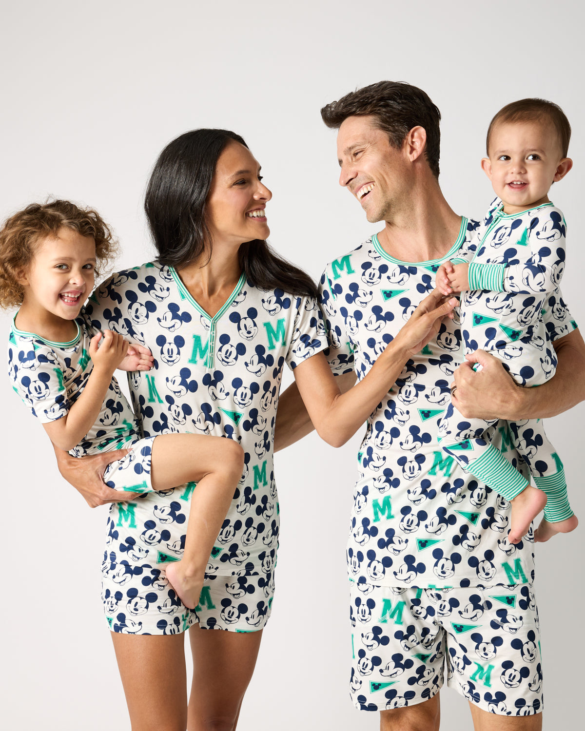 Family of four wearing matching Disney Varsity Mickey Mouse pajamas