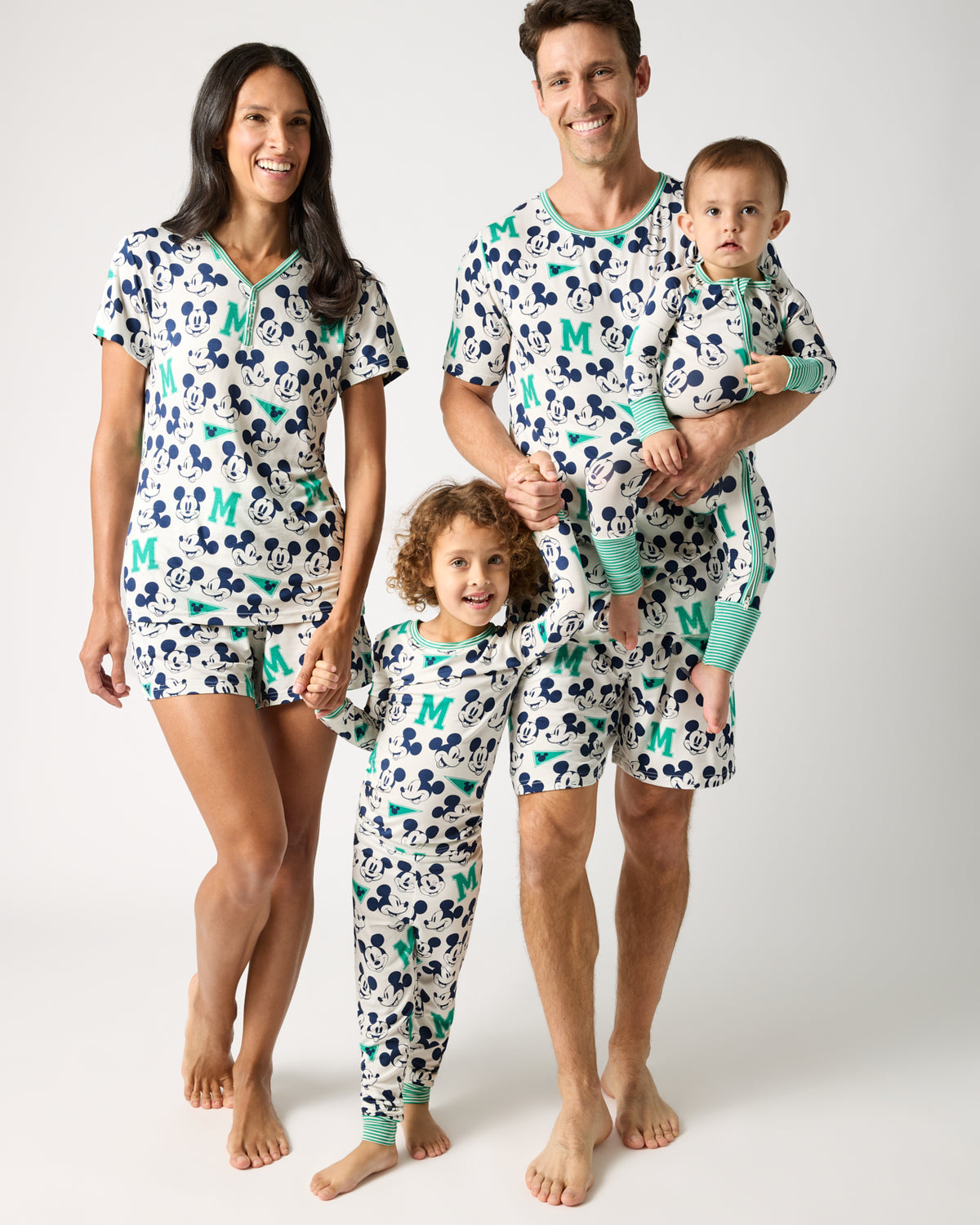 Family of four wearing matching Disney Varsity Mickey Mouse themed pajames