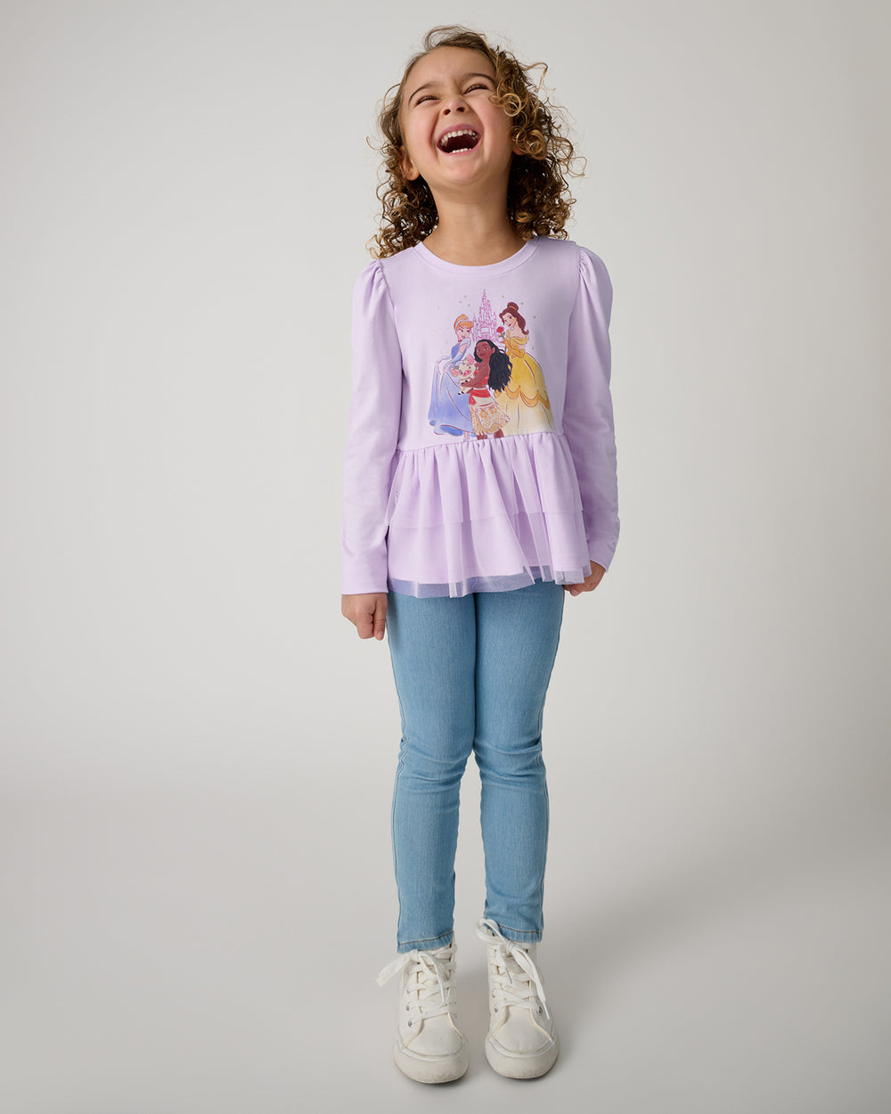Girl wearing the Disney Castle Daydream Peplum Top with blue denim pants