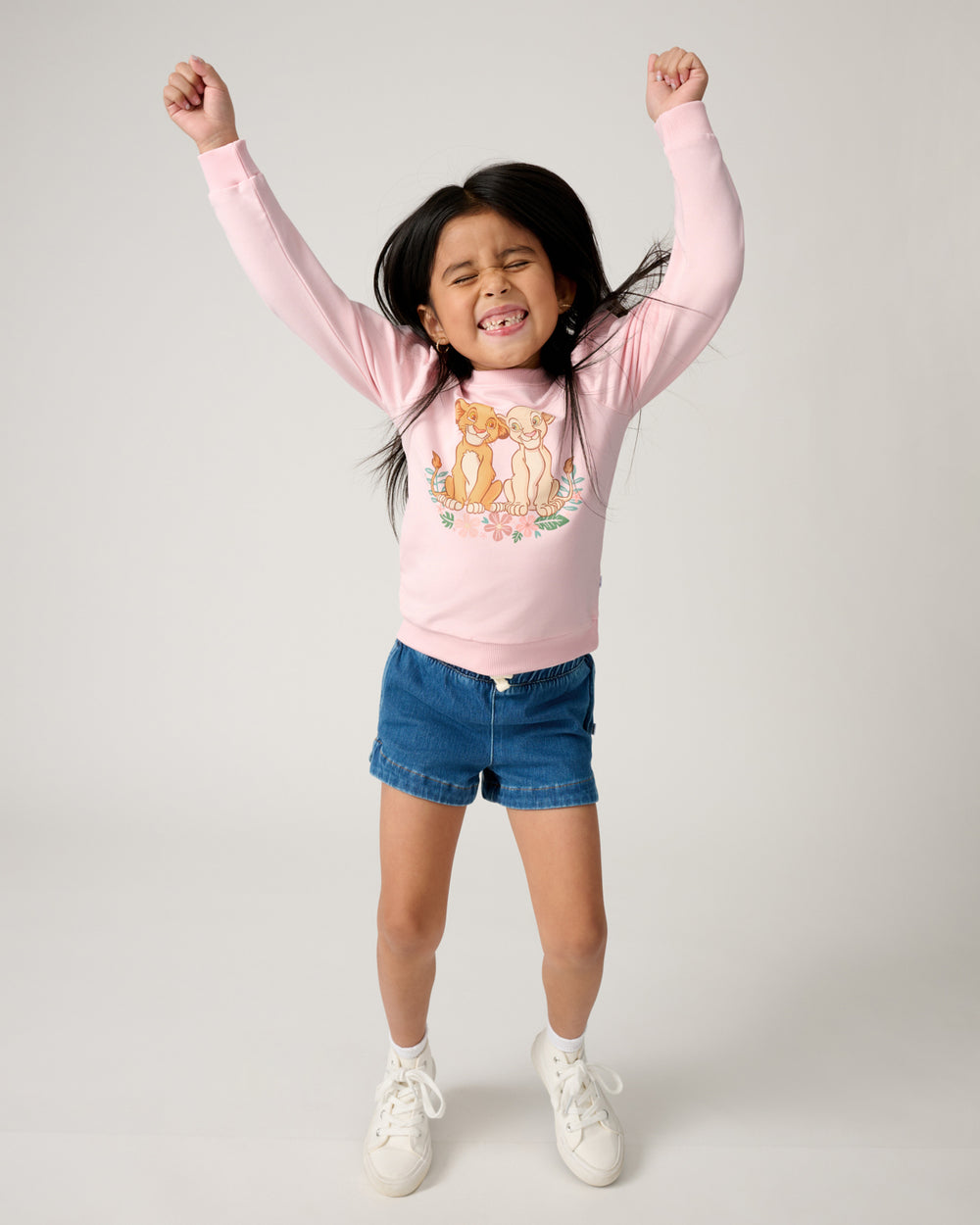 Jumping girl wearing the Disney Cub Club Puff Sleeve Crewneck