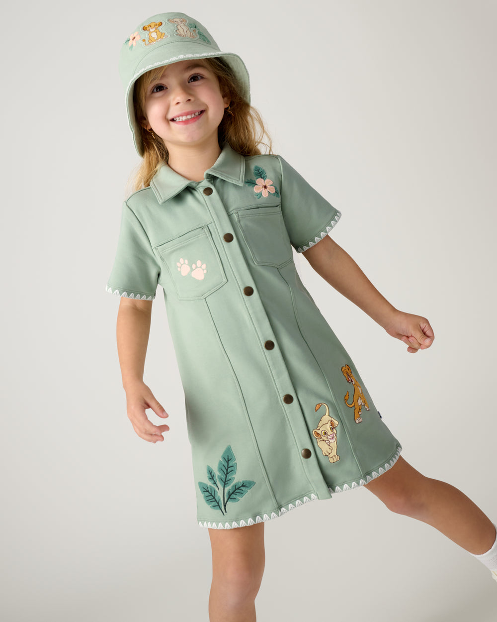 Close up of girl wearing the Disney Cub Club Button Dress and Bucket Hat