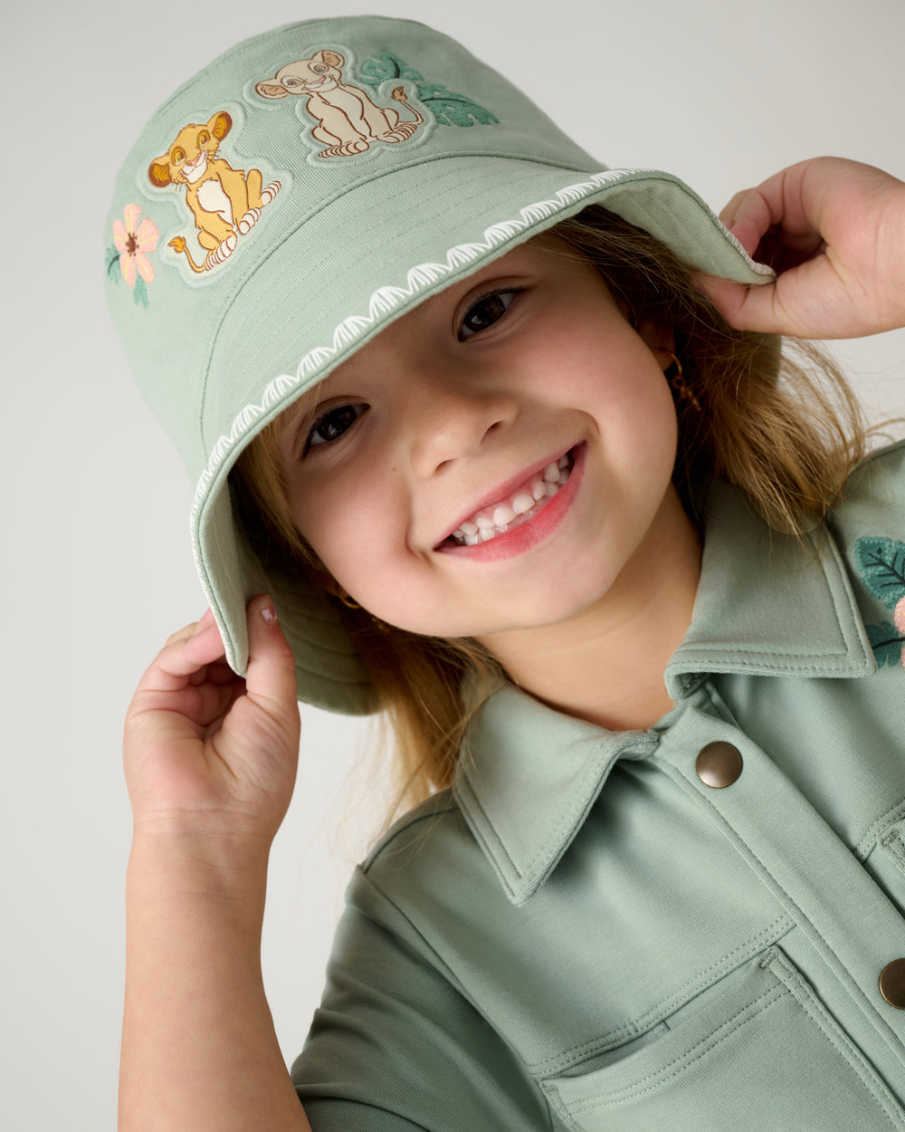 Close up of girl wearing the Disney Cub Club Bucket Hat