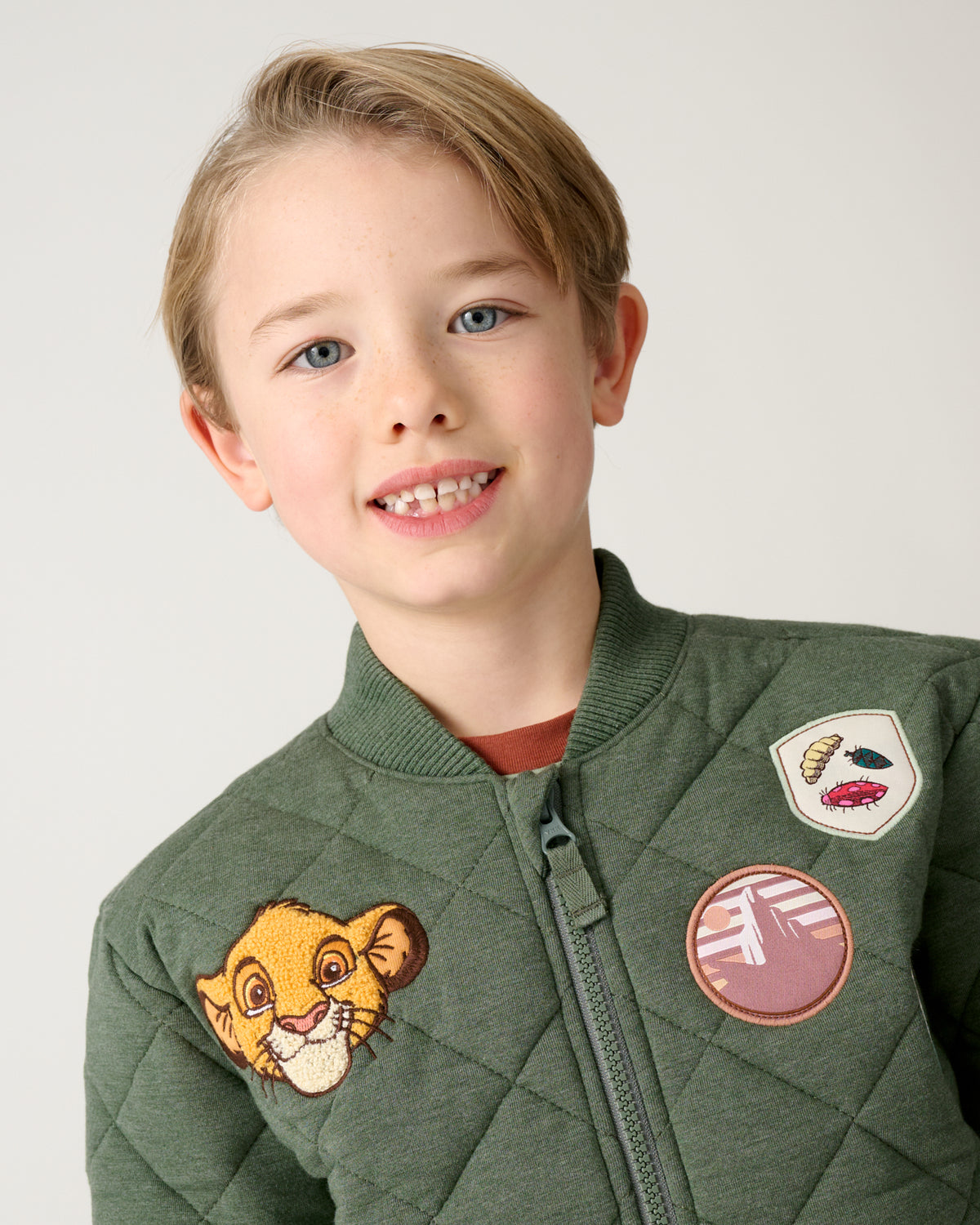 Close up of boy wearing the Disney Explore The Wild Quilted Varsity Jacket