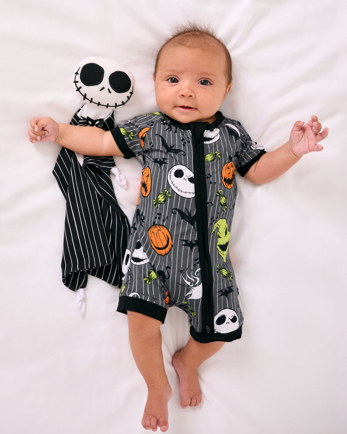 Aerial view of baby wearing the Disney The Nightmare Before Christmas Shorty Zippy laying with a halloween lovey