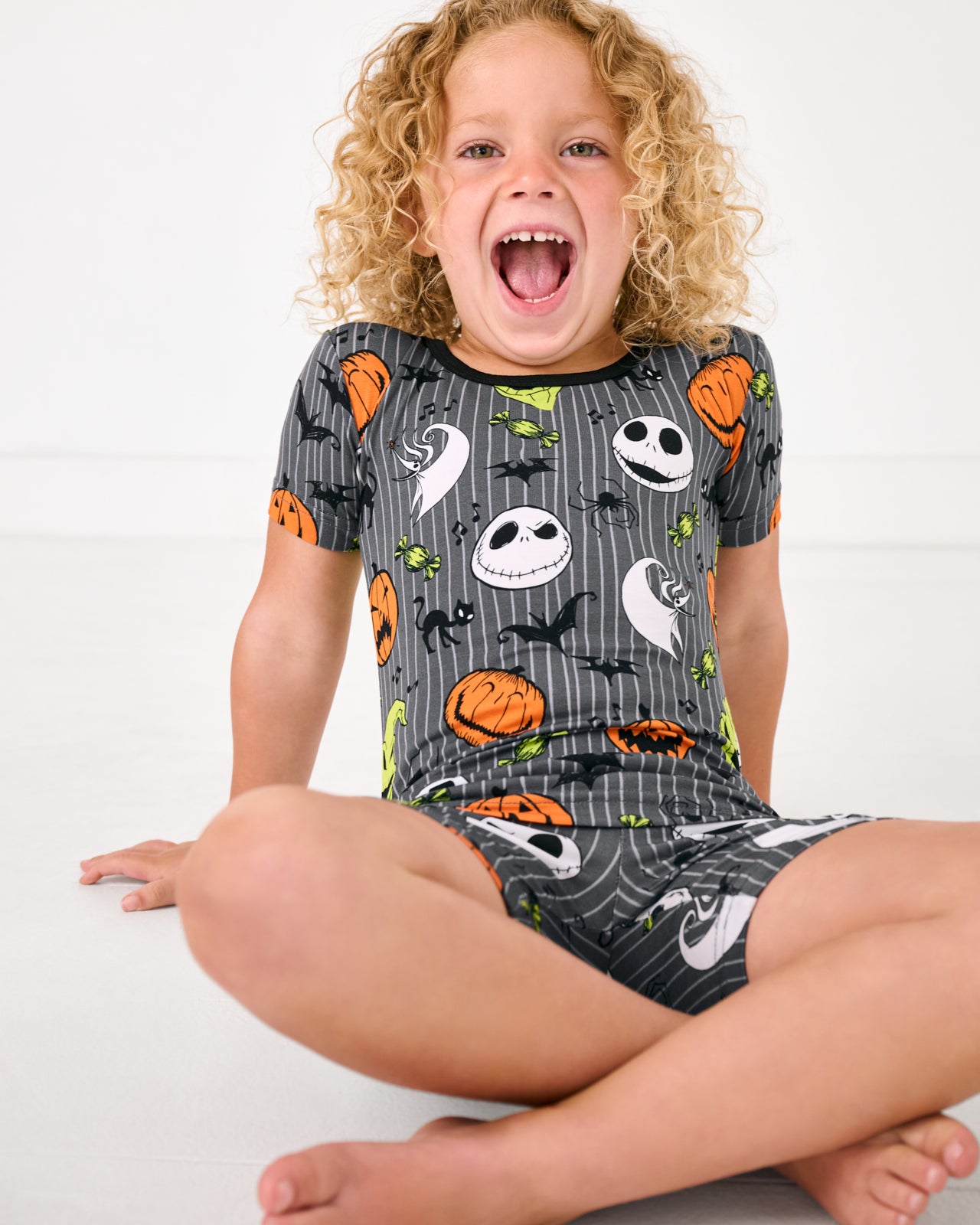 Sitting girl wearing the Disney The Nightmare Before Christmas Two-Piece Short Sleeve & Shorts Pajama Set