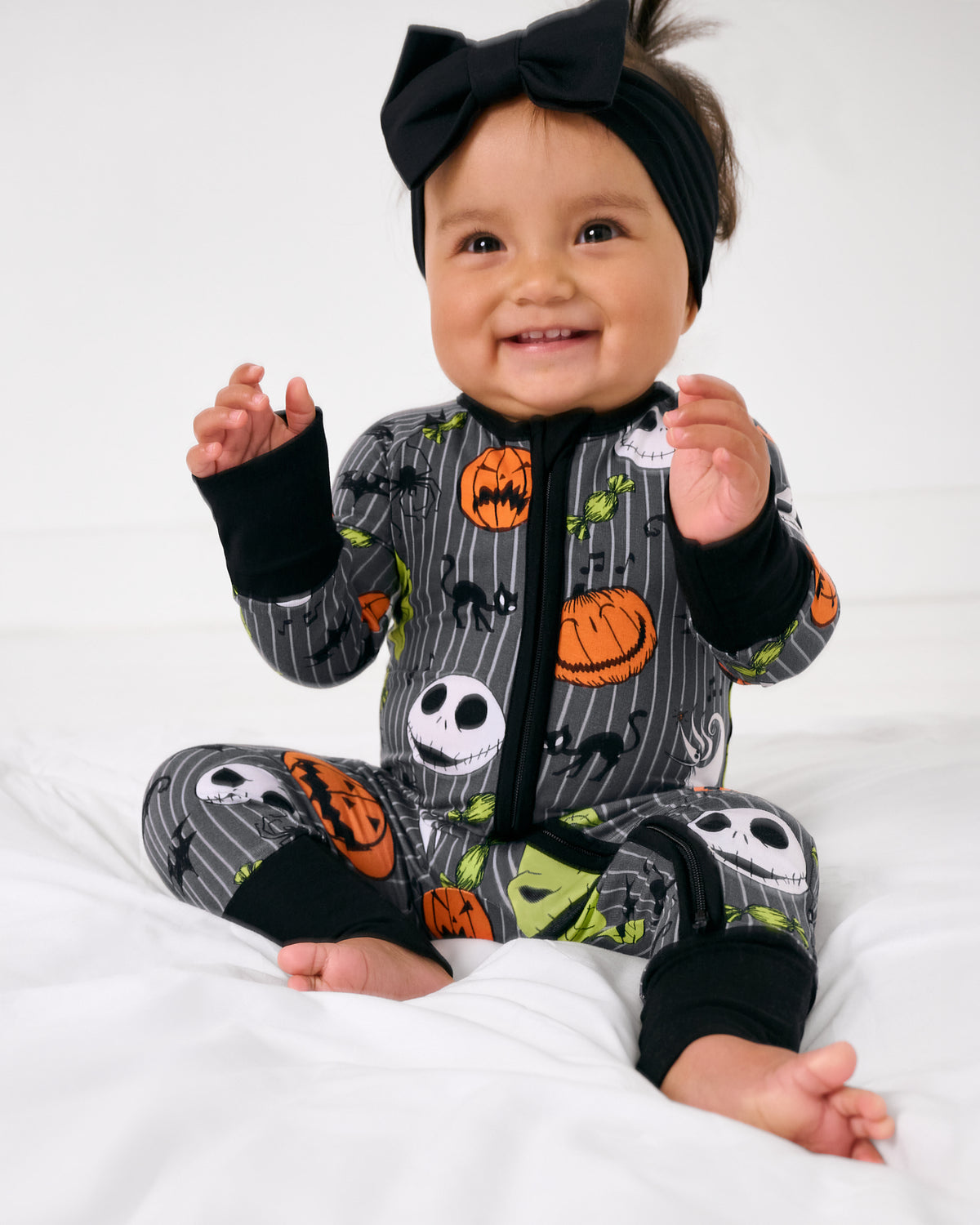 Sitting child wearing the Disney The Nightmare Before Christmas Zippy with a black bow headband