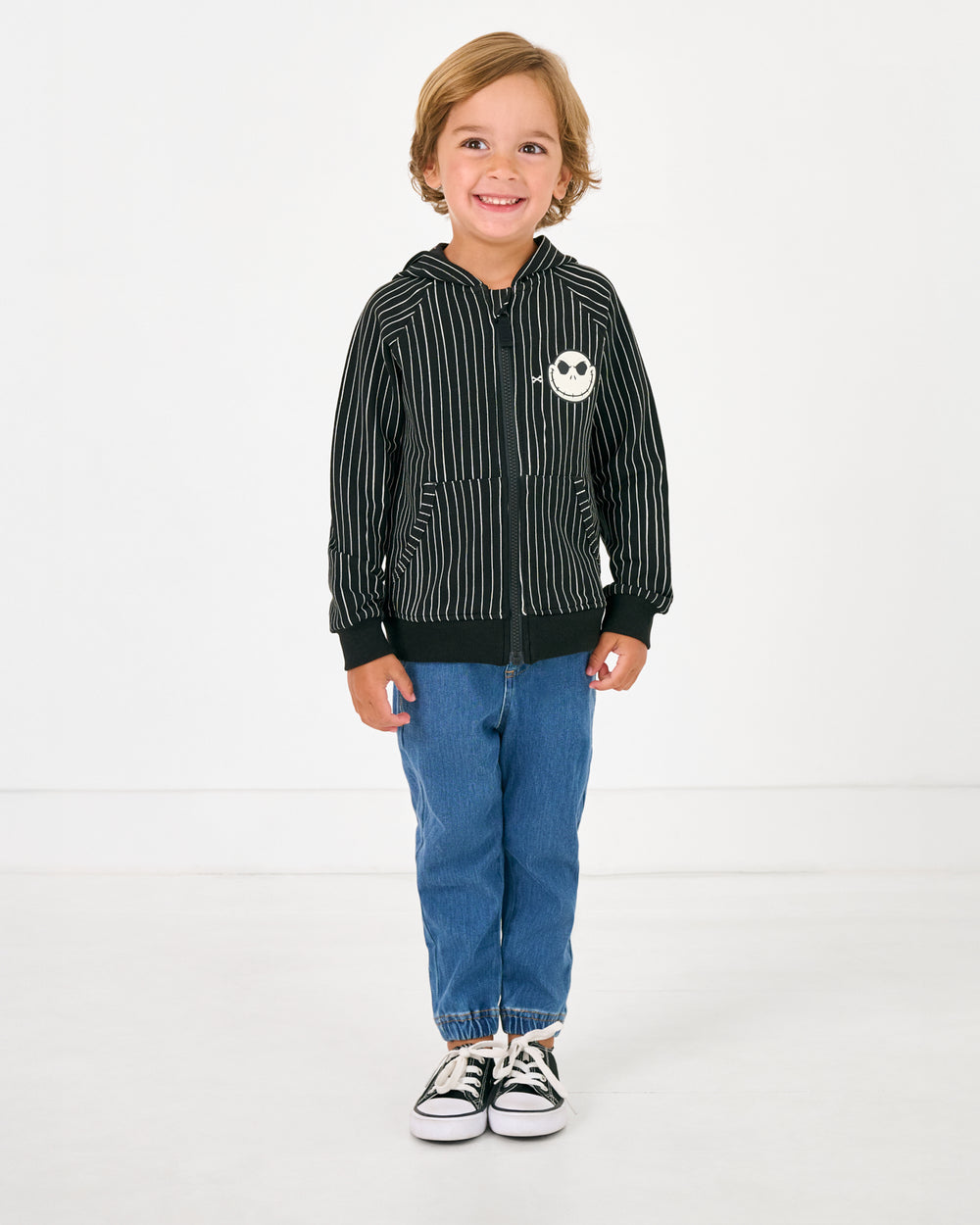 Boy wearing the Disney Jack Skellington Zip Hoodie with denim joggers