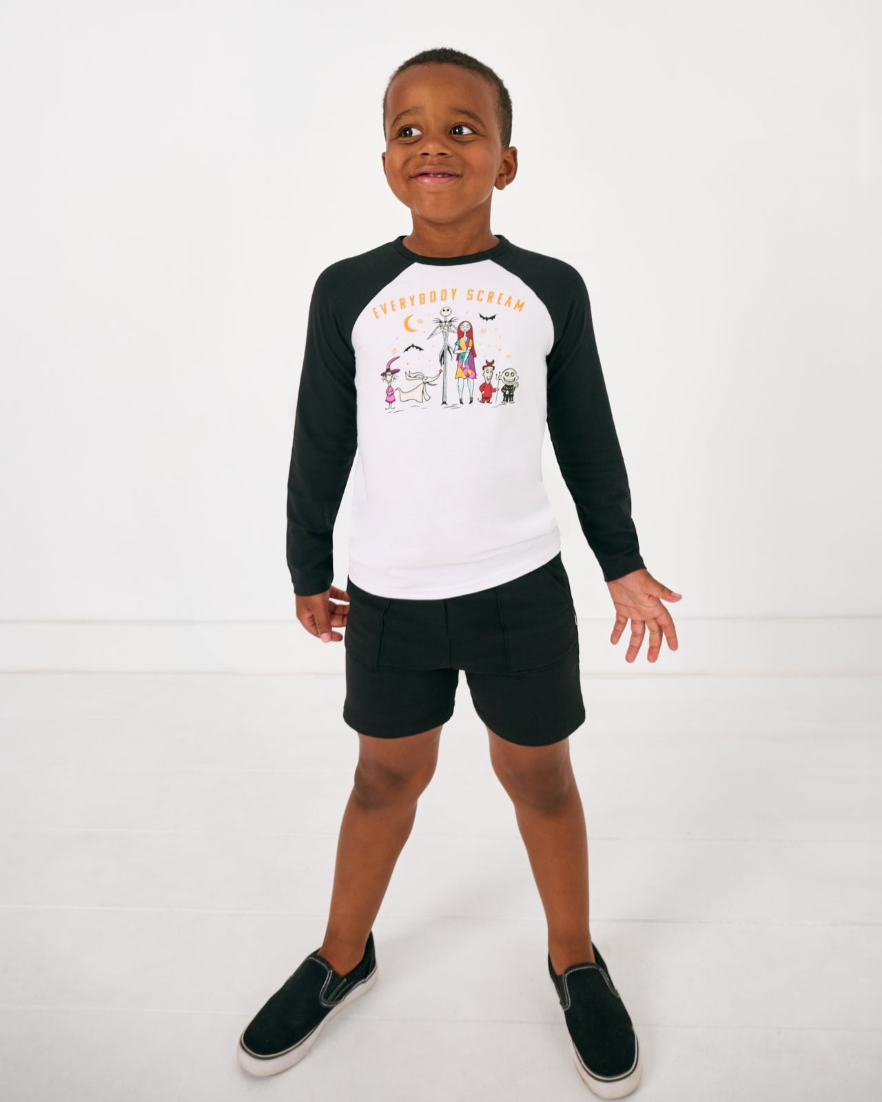 Standing boy wearing the Disney Everybody Scream Raglan Tee with black shorts