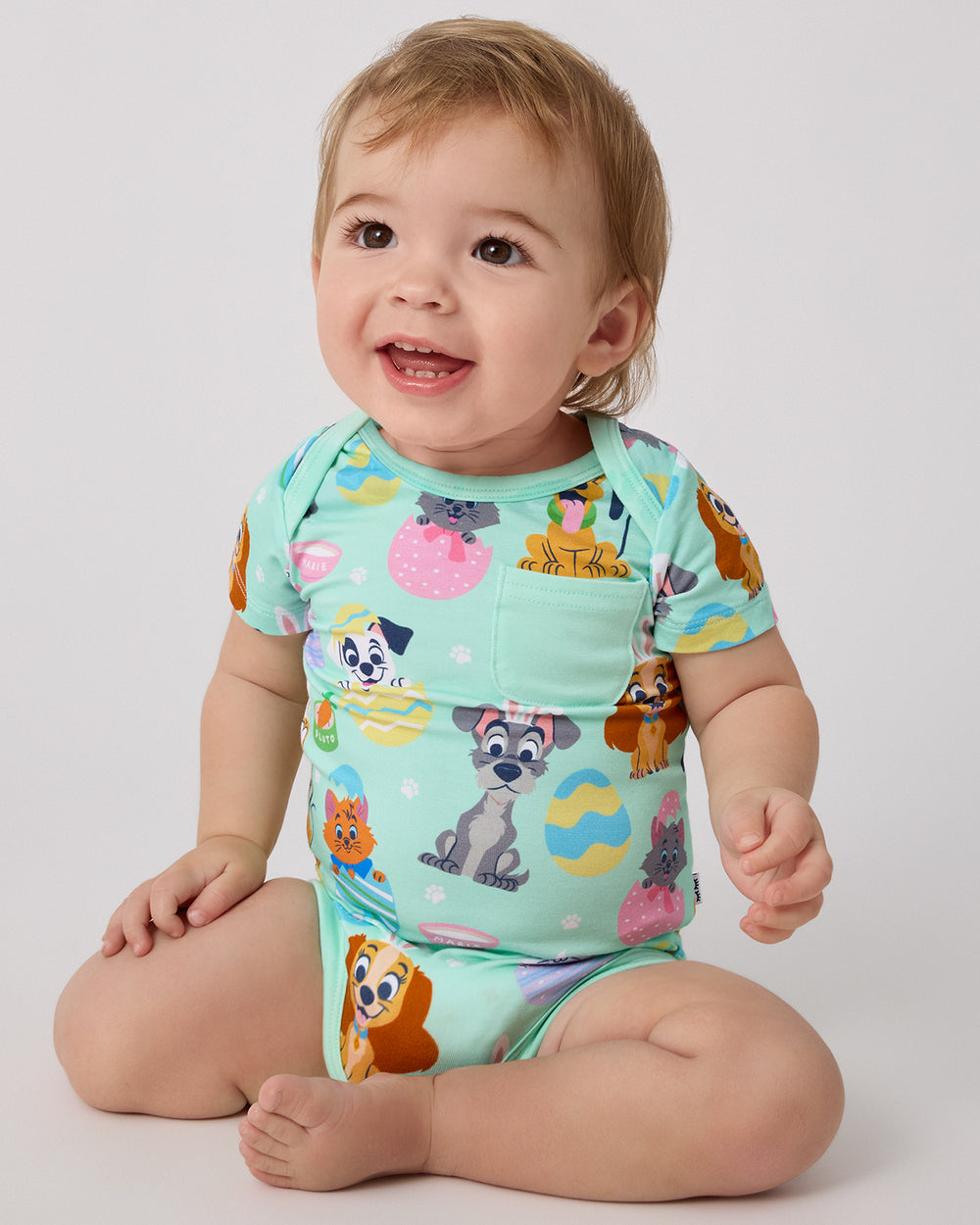 Sitting baby wearing the Disney Peekaboo Pets Pocket Bodysuit
