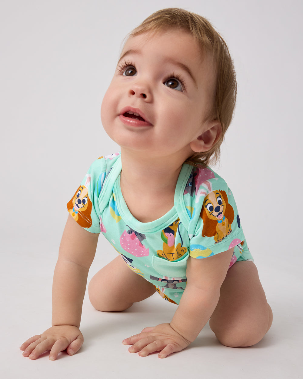 Crawling baby wearing the Disney Peekaboo Pets Pocket Bodysuit