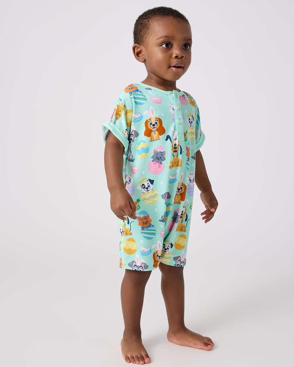 Standing child wearing the Disney Peekaboo Pets Dolman Henley Romper