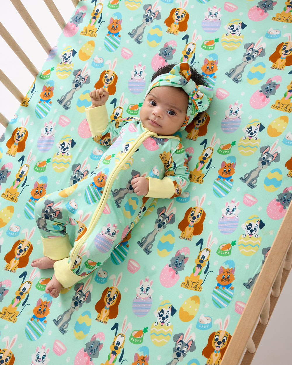 Baby laying in a crib with the Disney Peekaboo Pets Fitted Crib Sheet