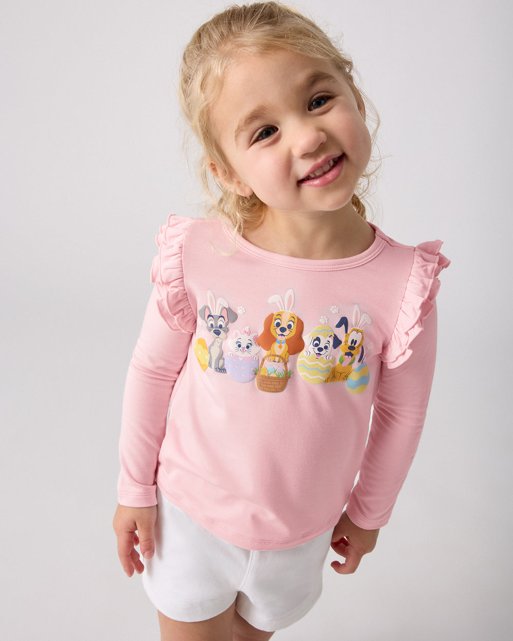 Girl wearing the Disney Peekaboo Pets Flutter Tee with white shorts