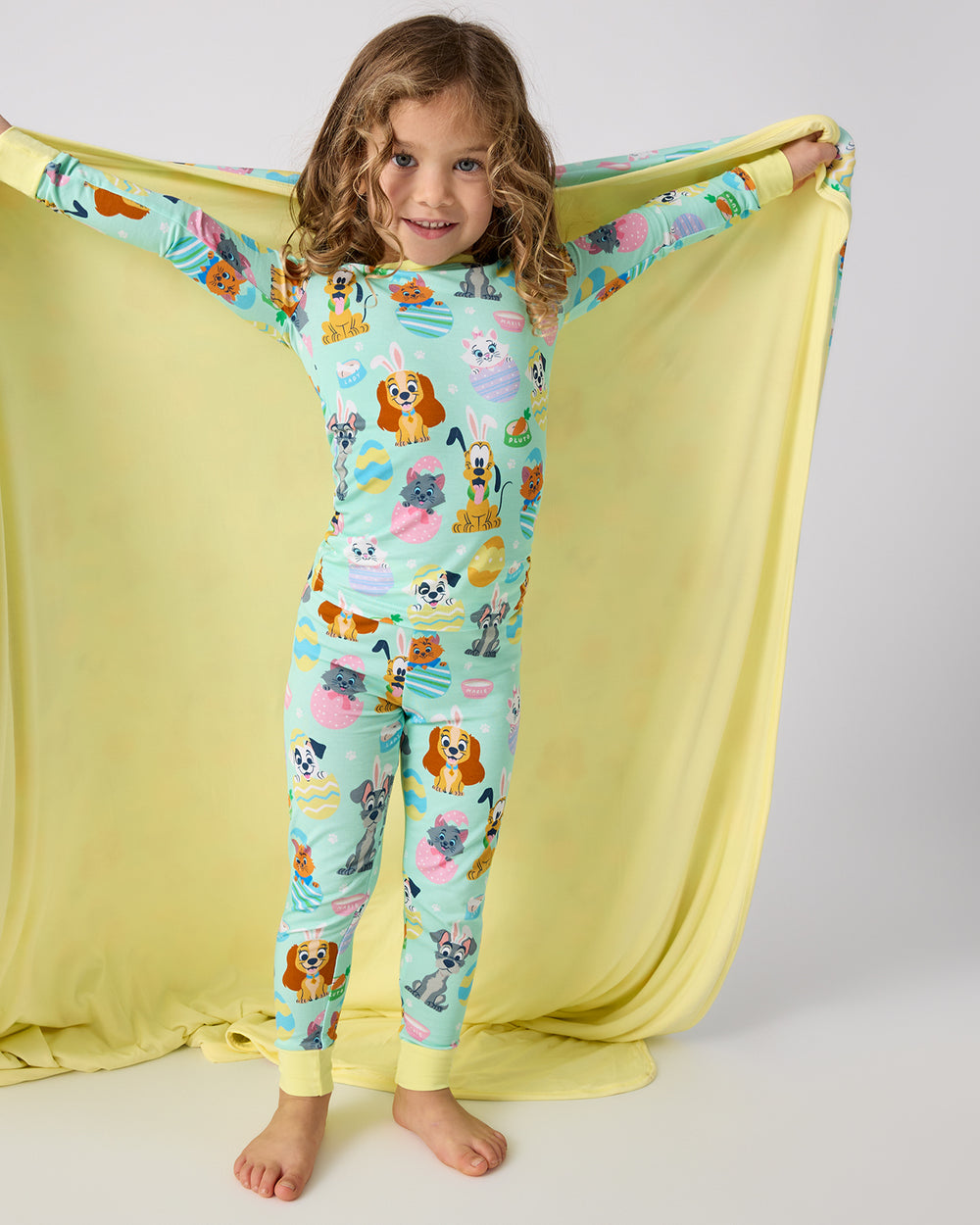 Standing girl holding the Disney Peekaboo Pets Large Cloud Blanket® showing the solid yellow side