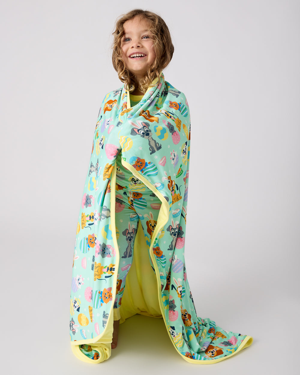 Standing girl wrapped in the Disney Peekaboo Pets Large Cloud Blanket®