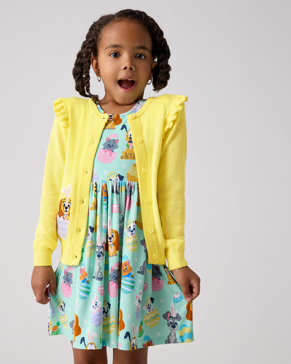 Girl wearing the Disney Peekaboo Pets Ruffle Cardigan layered over a dress