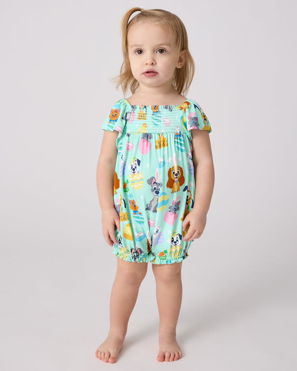 Standing child wearing the Disney Peekaboo Pets Smocked Flutter Romper