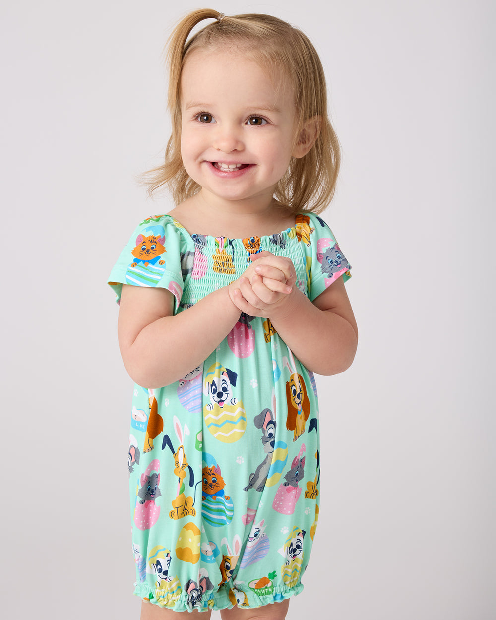 Standing girl wearing the Disney Peekaboo Pets Smocked Flutter Romper
