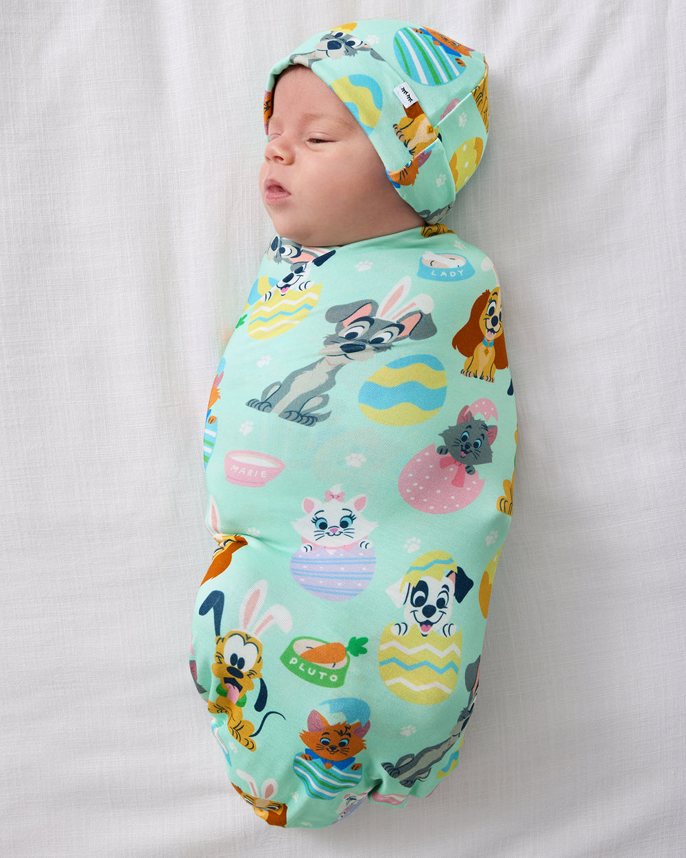 Aerial view of baby wearing the Disney Peekaboo Pets Swaddle & Hat Set