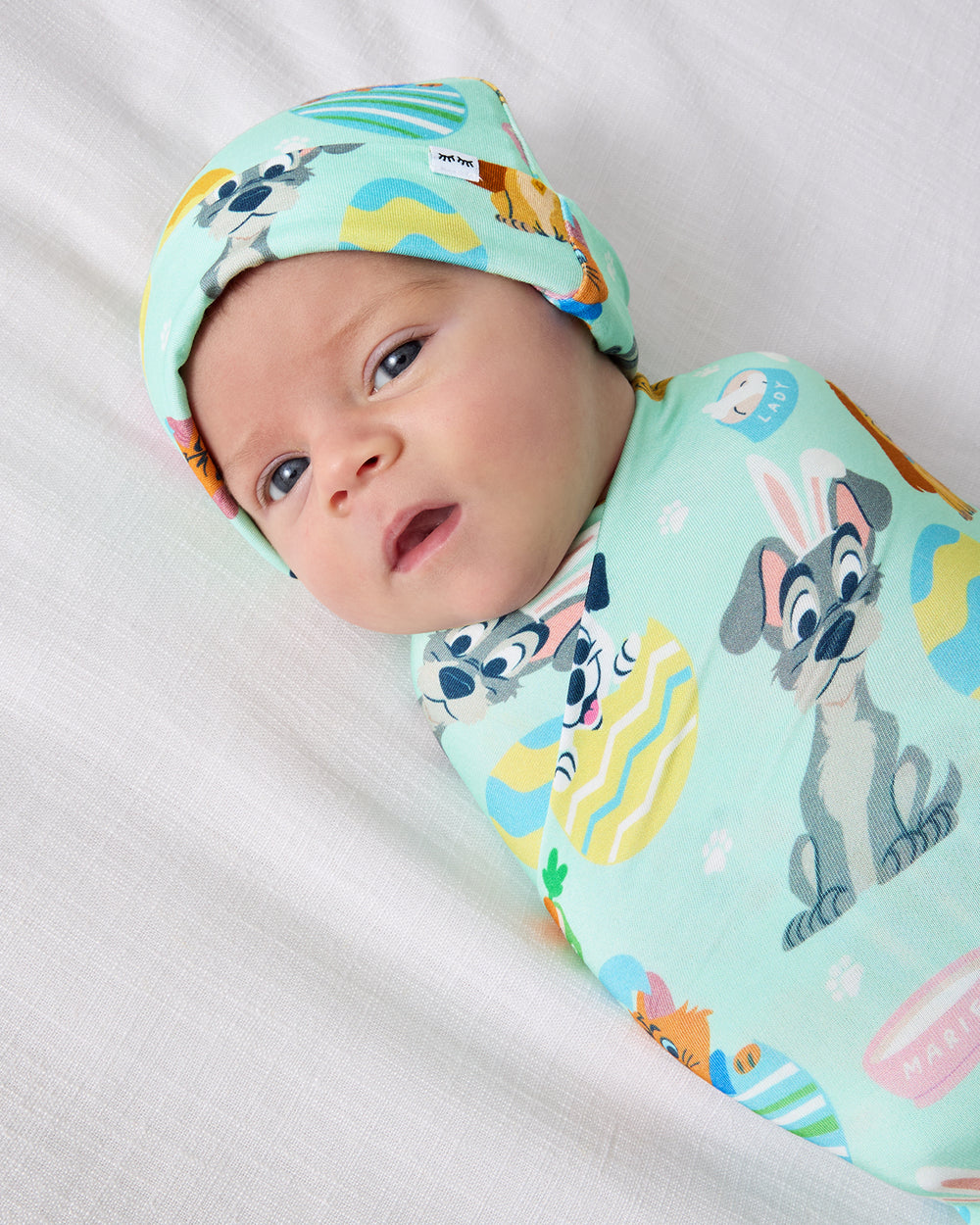 Close up of baby wearing the Disney Peekaboo Pets Swaddle & Hat Set