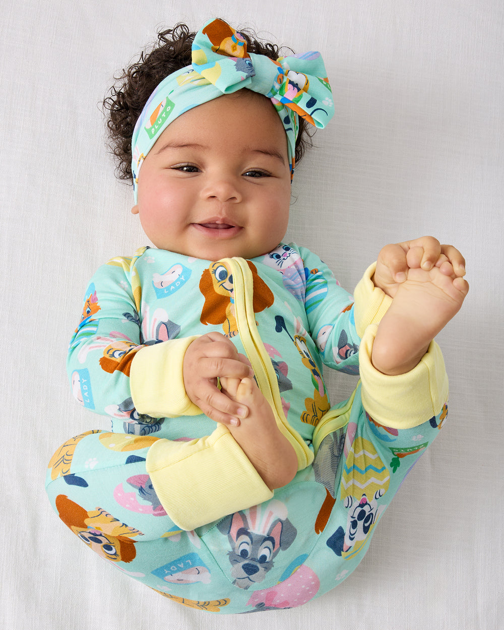 Aerial view of baby wearing the Disney Peekaboo Pets Zippy and matching luxe bow headband