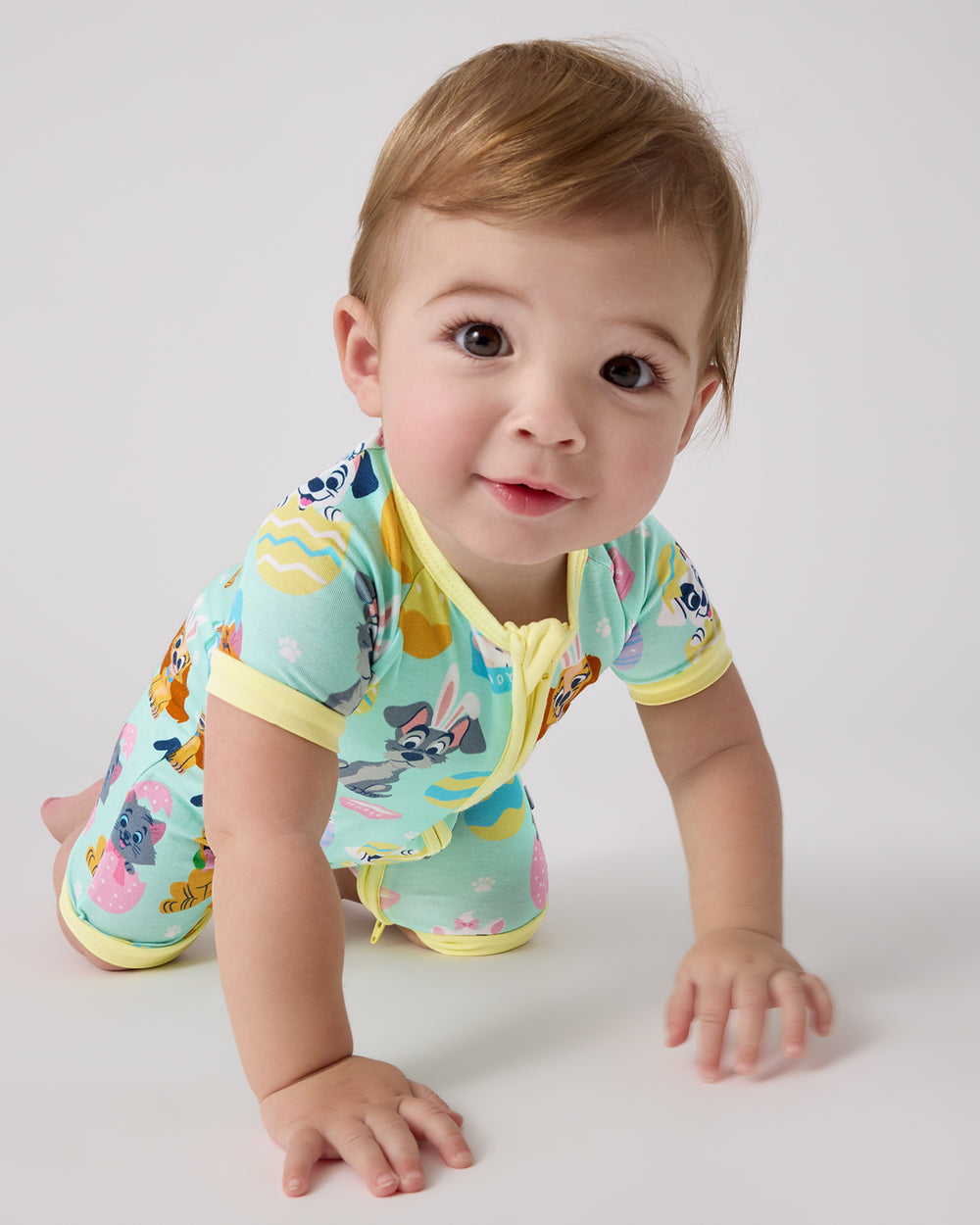 Crawling baby wearing the Disney Peekaboo Pets Shorty Zippy