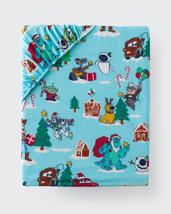 Flat lay of the Disney & Pixar Christmas Village Fitted Crib Sheet