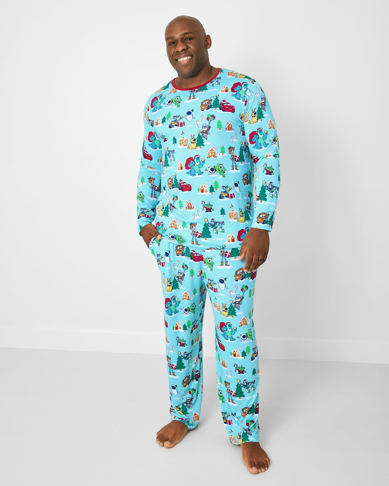 Man wearing the Disney & Pixar Christmas Village Men's Pajama Pants with a matching pajama top