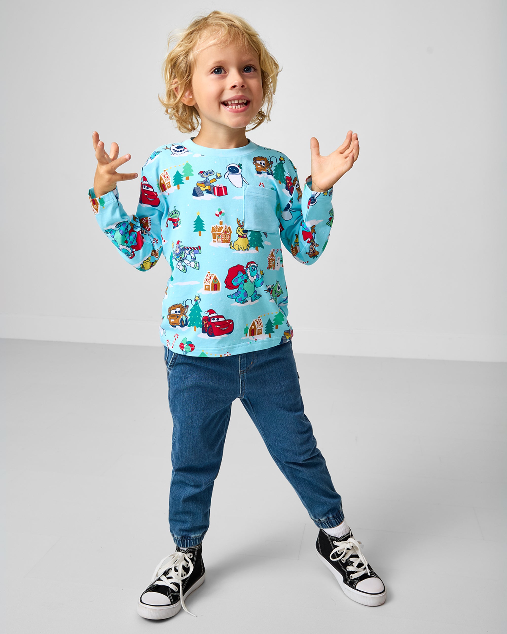 Child wearing the Disney & Pixar Christmas Village Relaxed Pocket Tee with denim joggers