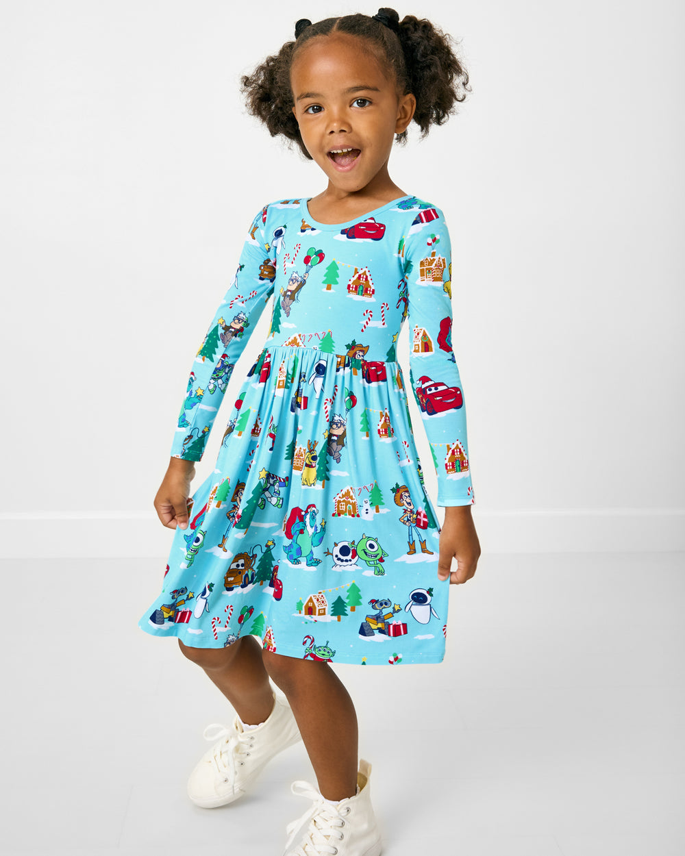 Posing girl wearing the Disney & Pixar Christmas Village Skater Dress