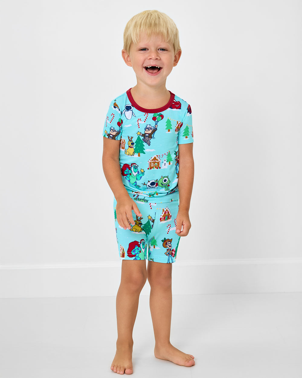 Boy wearing the Disney & Pixar Christmas Village Two-Piece Short Sleeve & Shorts Pajama Set