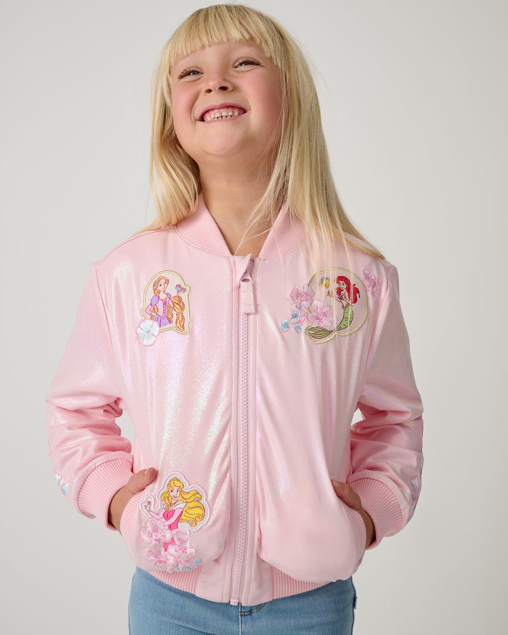 Girl wearing the Disney Princess Iridescent Varsity Jacket zipped up