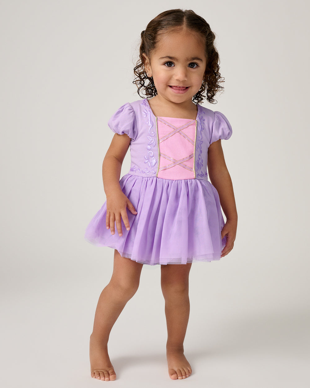 Standing toddler wearing the Disney Princess Rapunzel Dress with Bodysuit