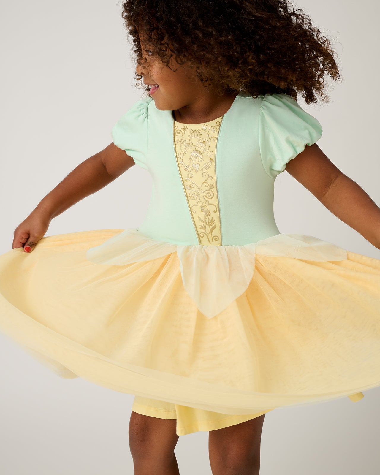Alternate of girl wearing the Disney Princess Tiana Dress holding out the mesh skirt