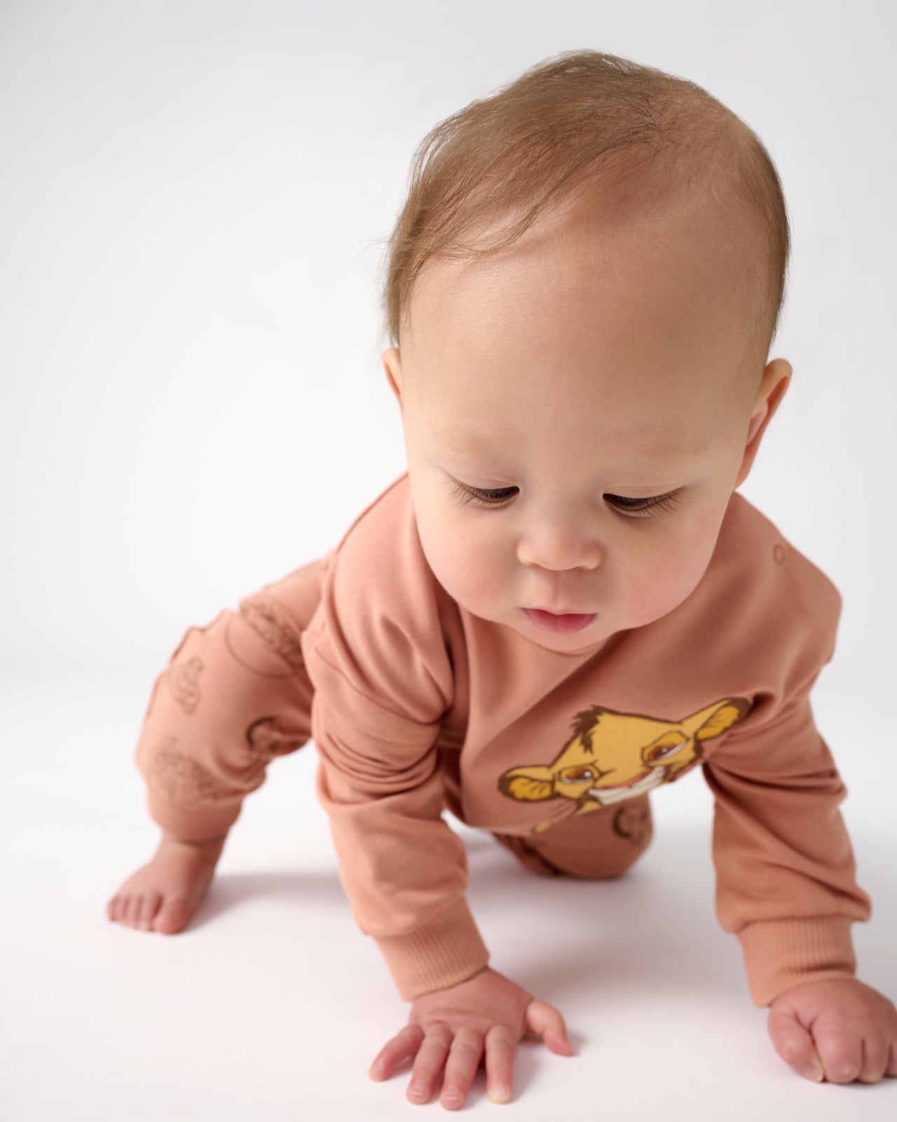 Crawling baby wearing the Disney Simba Easy Crewneck Sweatshirt