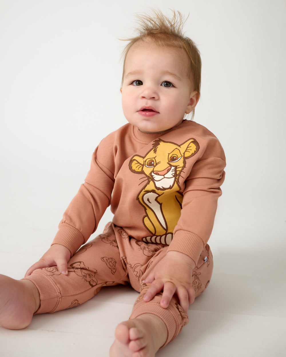 Sitting baby wearing the Disney Simba Easy Crewneck Sweatshirt and Sweatpants