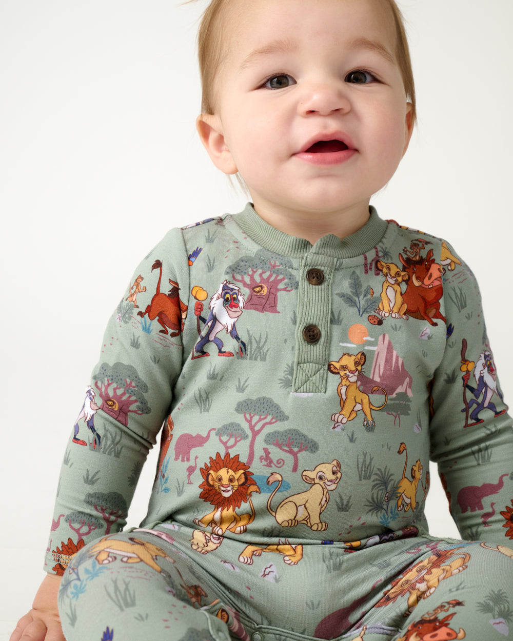 Close up of sitting baby wearing the Disney Simba's Safari Henley Romper