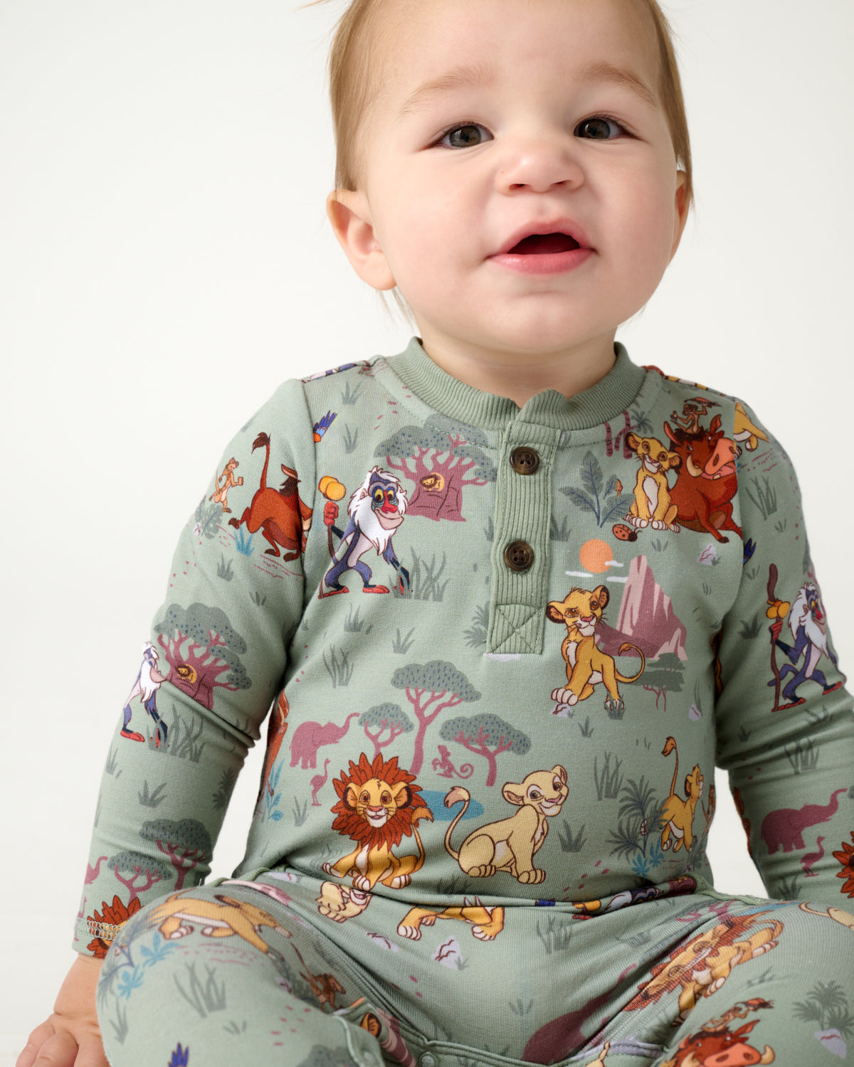Close up of sitting baby wearing the Disney Simba's Safari Henley Romper